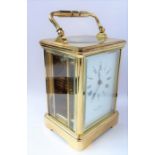 A good modern gilt-metal and glass-sided carriage clock timepiece; the white-enamel dial with