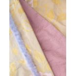 A pair of silk curtains in a modern floral design of pink and gold edged with lilac fur-effect