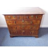 An early 18th century walnut veneered chest; the quarter-veneered, crossbanded and feather-banded