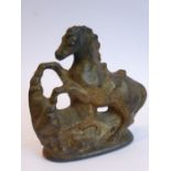 A very heavy cast-iron and gold-painted door stop modelled as a rearing horse before rocks etc. (