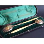 A cased pair of 19th century hallmarked silver-gilt salad servers; turned ivory handles and