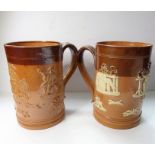 Two similar 19th century salt glaze Doulton Lambeth tankards; typically decorated in relief with