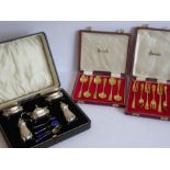 An early 20th century cased five-piece hallmarked silver cruet set comprising two salts with blue-
