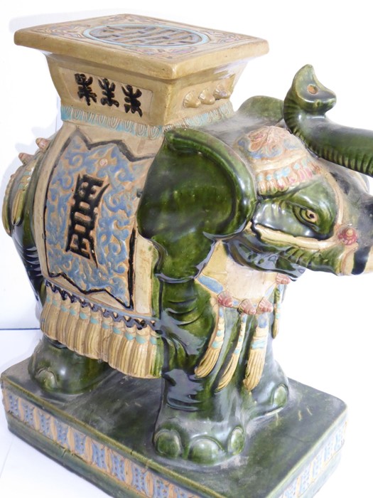 A large Chinese stoneware jardinière stand modelled as a trumpeting elephant; the central howdah