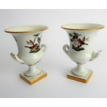 A pair of Herend porcelain two-handled campana-style urns; hand gilded and decorated with