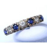 A sapphire and white sapphire half hoop ring, the four circular-cut sapphires each separated by a