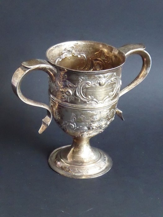 An 18th century hallmarked silver two-handled trophy-style cup; later Repoussé decorated and with