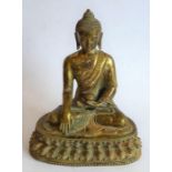 A Tibetan gilt bronze medicine Buddha; the Buddha seated in dhyanasana on a double lotus throne,