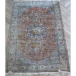 An early 20th century silk cashmere rug; with cobalt-blue ground and central medallion against a