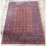 A machine made orange and red ground Turkman carpet in good condition (287cm x 200cm)