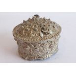 A heavy cast circular silver metal coloured box and cover of Eastern inspiration (possibly Indian/