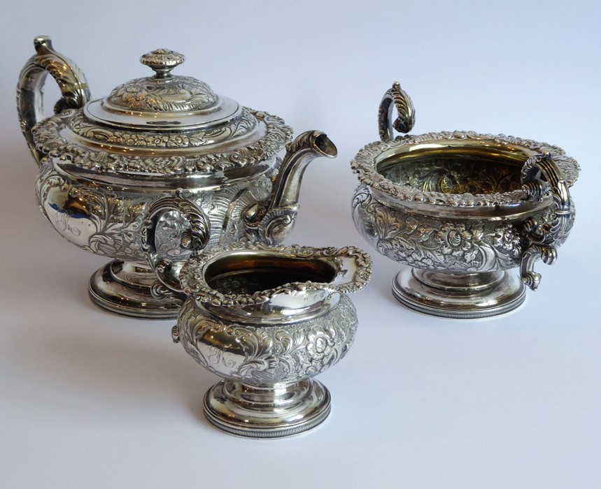 A heavy early 19th century hallmarked silver three-piece tea service: teapot, large two-handled