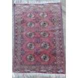 A small red ground Afghan rug with gul pattern (124cm x 85cm)