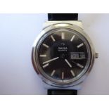 A gentleman's steel-cased Omega Quartz wristwatch; the signed black dial with baton markers and