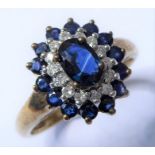 A sapphire and diamond set cluster ring; the central oval mixed-cut sapphire above a surround of