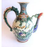 An early 20th century Japanese wine ewer decorated in the Satsuma style; the curling handle modelled