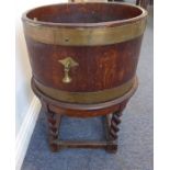 An early 20th century brass-bound oak planter/wine cooler; the cylindrical barrel with maker's label
