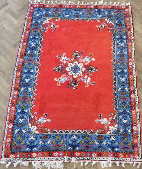 A Moroccan Rabat carpet; central flowerheads against a red ground within blue and red varying