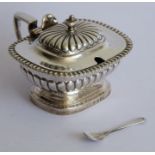 An early 19th century hallmarked silver mustard; boat-shaped with lobed lid and lower body raised on