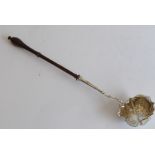 A mid-18th century silver and fruitwood toddy ladle; the lobed bowl embossed with floral,