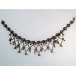 An Indian-inspired fringe necklace, the flowerhead clusters suspending an ornate graduated chain and