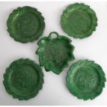 A set of four finely moulded green leaf ceramic dishes, together with one other similar example with