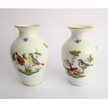 A pair of Herend porcelain vases of baluster form; decorated with two songbirds and insects in