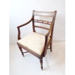 A single early 19th century Regency period mahogany open armchair; the figured tablet shaped concave