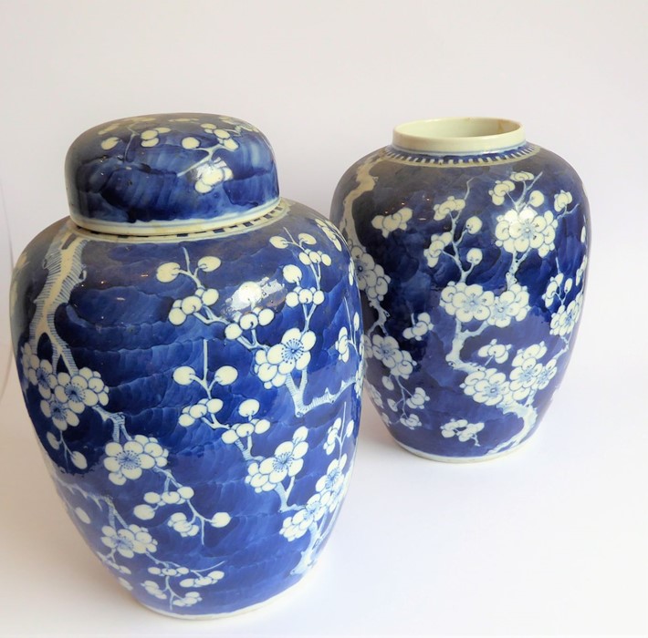 A pair of late 19th century Chinese baluster-shaped vases in Kangxi-style (one minus lid); each