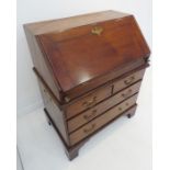 An mid-18th century walnut writing bureau of small proportions; the well-figured fall with cleated