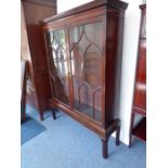 A George III period mahogany display cabinet; dentil cornice above two glazed doors with astragal