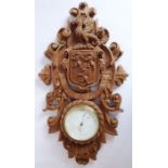 A wood-framed barometer; carved in high relief with a three-lion armorial and Old French legend, '