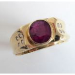 A gentleman's large 9-carat gold ring centrally set with a hand-cut red stone (probably a ruby)