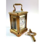 A miniature brass carriage clock with key