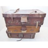 An early 20th century large leather travelling trunk together with two other leather trimmed/mounted