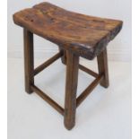 A late 19th/early 20th century saddle seat-style stained pine stool
