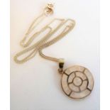 A circular silver pendant set with small mother of pearl squares, together with a silver chain (