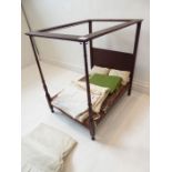 A late 19th/early 20th century mahogany-framed doll's four-poster bed. Complete with pillows,