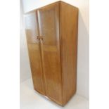 A fine quality Ercol-style elm wardrobe; two panelled doors opening to reveal hanging space,