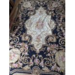 An unlined Aubusson tapestry in a floral geometric pattern in black and beige with a central