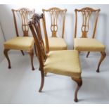 A set of four early 20th century walnut salon chairs; each with pierced splat, overstuffed seat