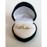 A lady's yellow-gold dress ring (unmarked); centrally set with a single pearl, ring size L, within a