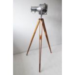 An original mid 20th century Strand 23 polished steel theatre light on an adjustable wooden tripod