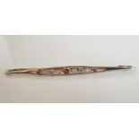 A late 19th/early 20th century 15-carat rose-gold bar brooch centrally set with a ruby flanked by