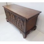 A small 16th century-style (reproduction) oak chest;  three-panel front carved with Gothic-style