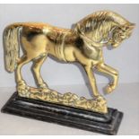 A late 19th / early 20th century doorstop in the form of a prancing brass horse upon a cast-iron