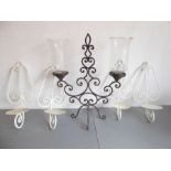 An ornate wrought-iron two-light candelabra with thistle-shaped glass shades, together with a set of