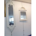 A modern white-painted vertical wall-hanging looking glass having foliate-style pediment and base (
