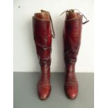 A pair of large, burgundy-leather gentleman's riding boots complete with wooden riding-boot trees