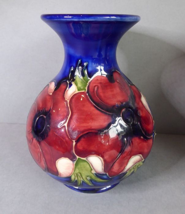 A small Moorcroft Pottery tube-lined bottle vase; of baluster-form and hand-decorated with anemones,